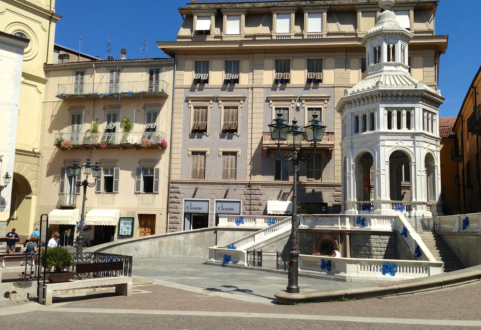 The octagonal marble kiosk of La Bollente hot spring in its sunny square in Acqui Terme