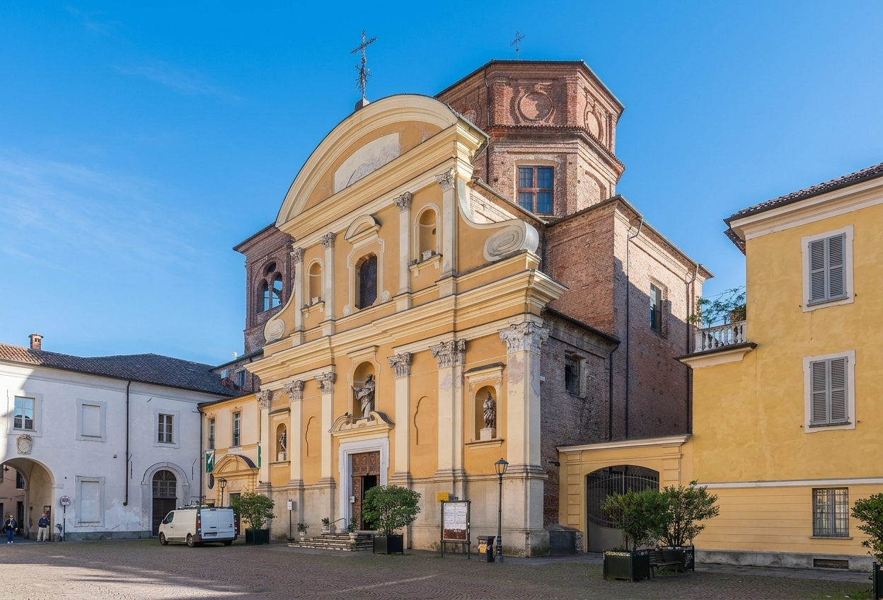 The yellow Baroque facade and brick drum of the church of San Martino on Piazza San Martino, Asti, under a blue sky