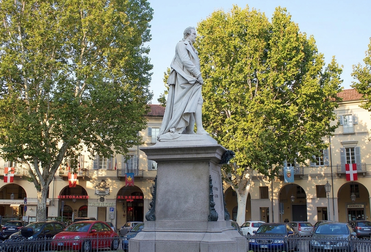 The statue of Vittorio Alfieri among trees and arcaded palazzi on Piazza Vittorio Alfieri, Asti
