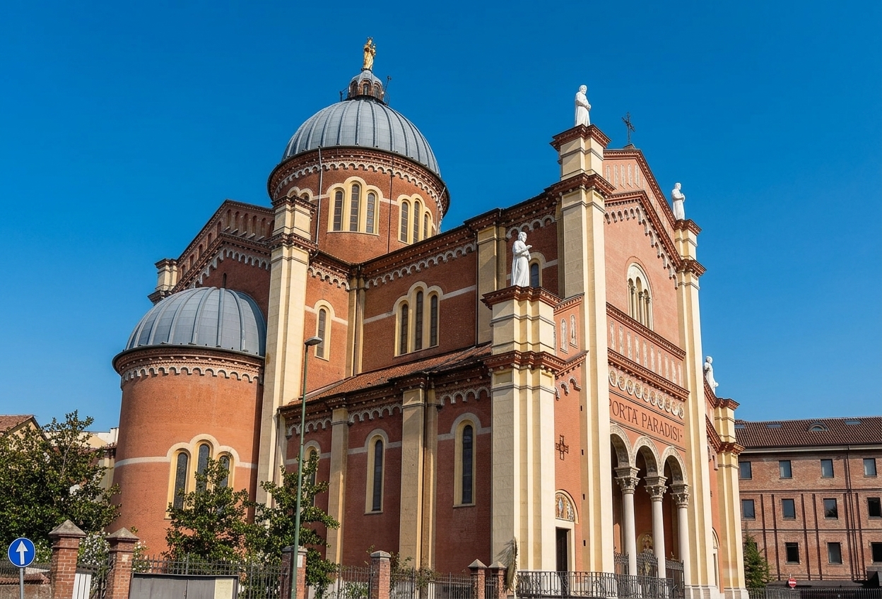 The striped brick Romanesque-Byzantine Santuario della Madonna del Portone in Asti, with its domes and gilded statue against a blue sky