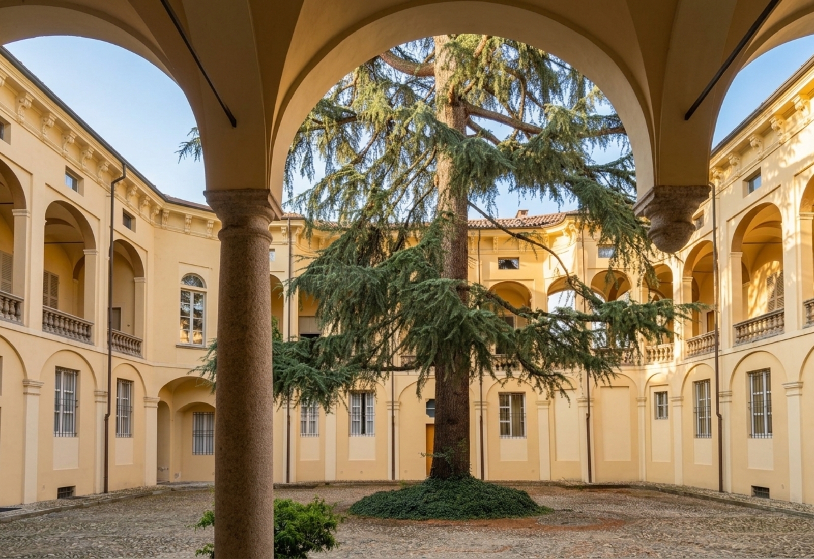 The arcaded courtyard and pale-yellow facade of Palazzo Sannazzaro in Casale Monferrato