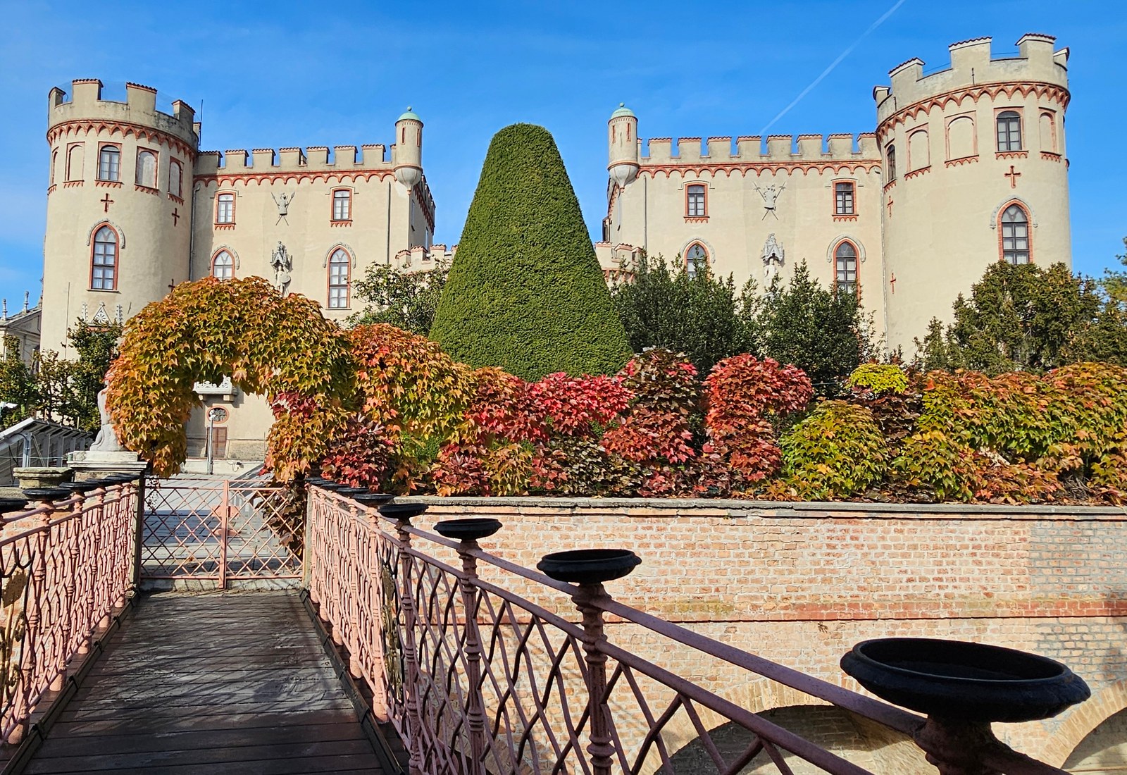 Castello di Costigliole d'Asti crowning the town, with its towers above an autumn garden