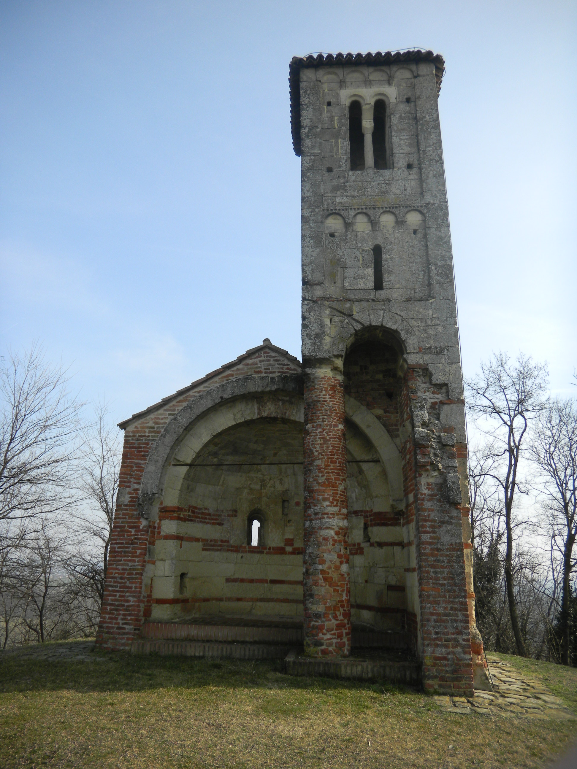 The Romanesque bell tower and surviving apse of the ruined church of San Vittore on a panoramic hilltop below Montemagno