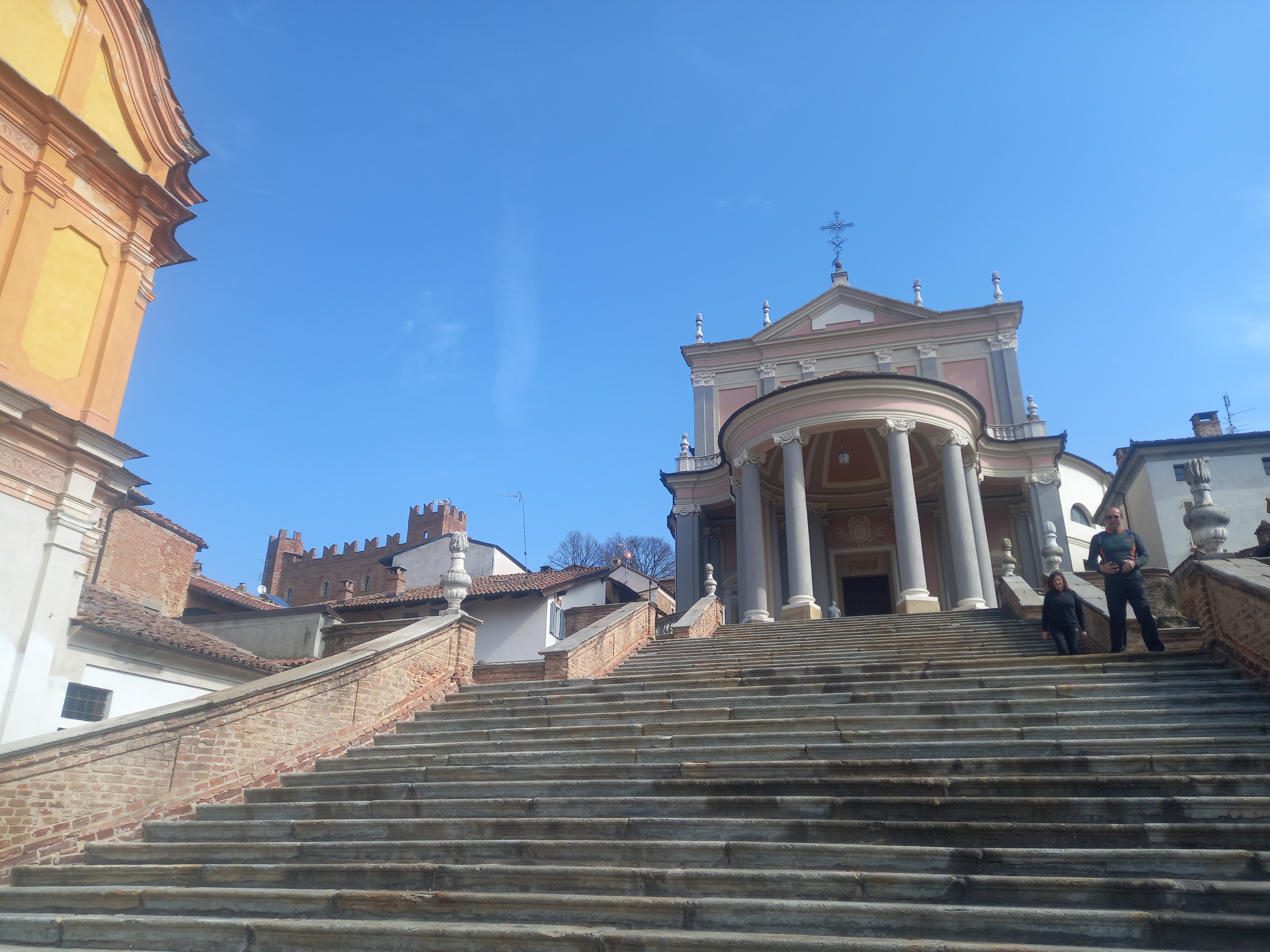 The monumental staircase of Piazza San Martino climbing to the Baroque parish church, the castle tower visible to the left
