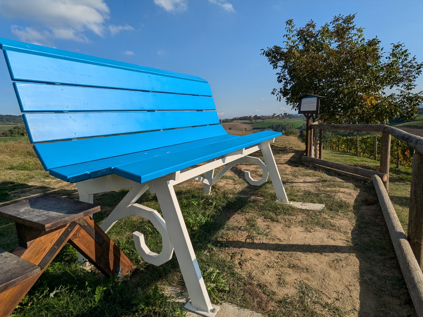 The sky-blue and white Big Bench #361 on the Colle Belvedere above Murisengo, with vineyards and hills beyond
