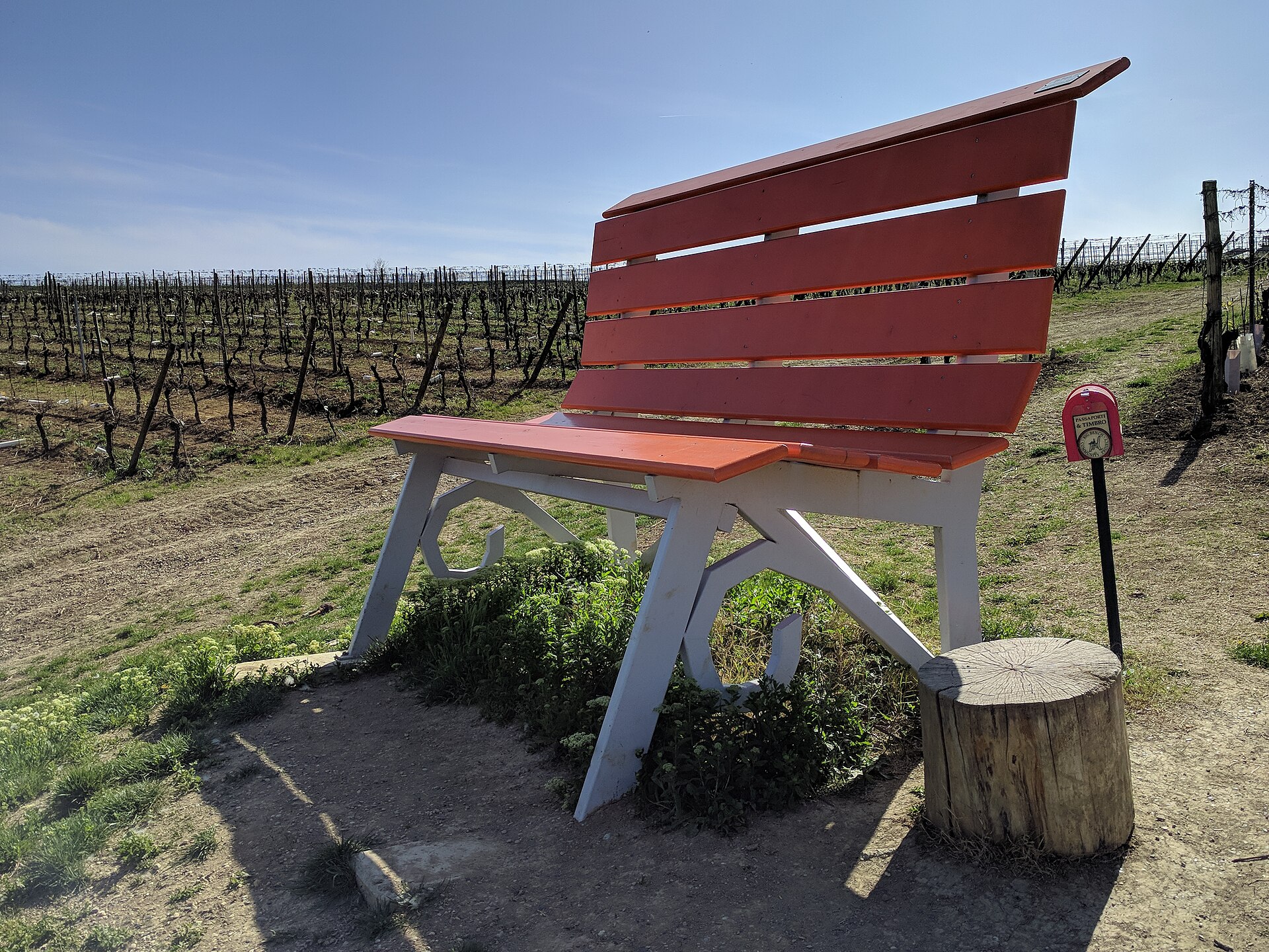 Big Bench No. 107, an oversized red bench overlooking the vineyards at Vignale Monferrato