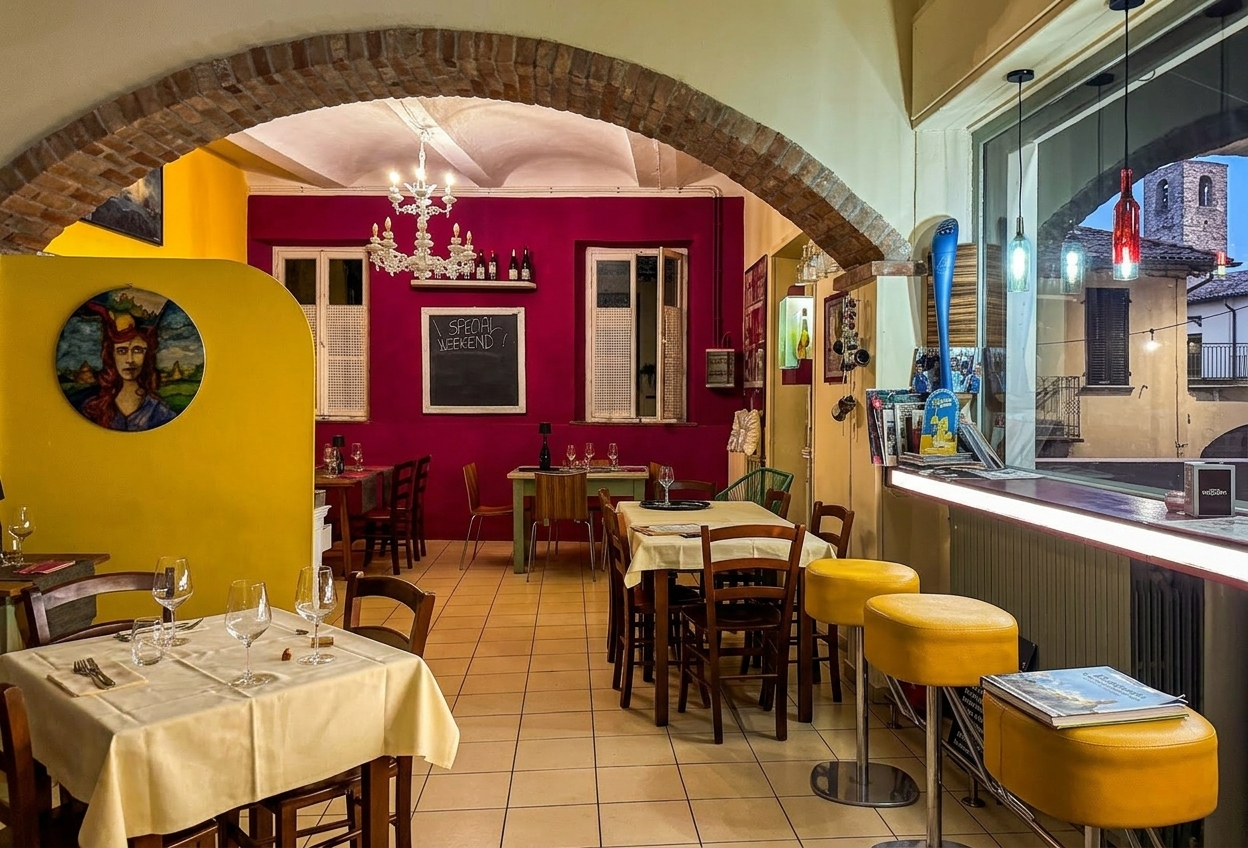 Interior of La Bottiglieria del Ruché wine bar in Castagnole Monferrato, tables set under a brick arch
