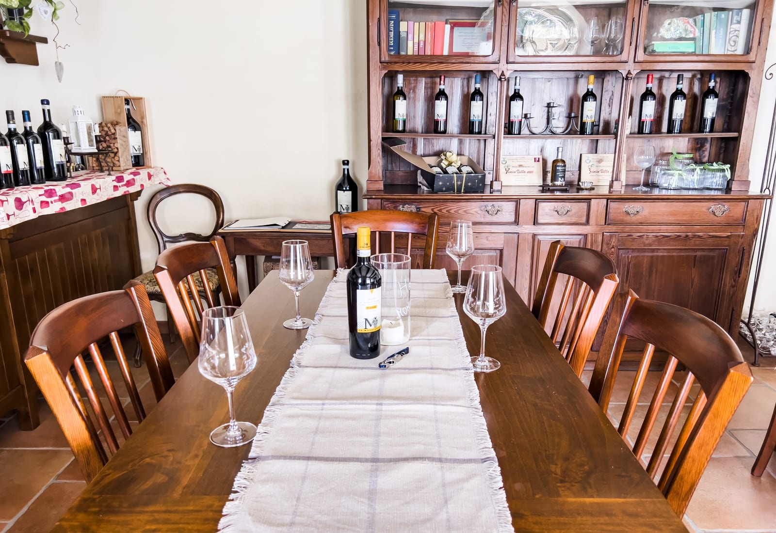 Tasting table set with glasses and La Mondianese wines in the estate's cellar room at Montemagno Monferrato